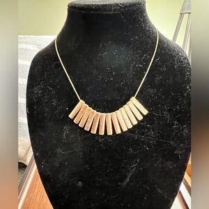 Gold tone bib necklace with geometric bar pendants in a fan shape. 16” 3.5”
Ext.